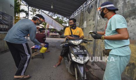 Pengendara sepeda motor diberikan cairan pembunuh kuman atau hand sanitizer oleh Satgas Penanggulangan COVID-19 Lingkungan saat memasuki gerbang Karang Kelok, Mataram, NTB, Senin (4/5/2020). Masyarakat di sejumlah lingkungan Kota Mataram secara mandiri memberlakukan Pembatasan Sosial Berskala Lingkungan (PSBL) dengan membatasi warga keluar masuk, mewajibkan menggunakan masker dan penyemprotan disinfektan sebagai upaya mencegah penyebaran COVID-19