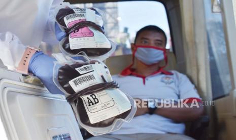 Petugas Unit Tranfusi Darah Palang Merah Indonesia (PMI) menunjukkan kantong berisi darah dari pendonor saat berlangsung donor darah di dalam mobil Unit Donor Darah di areal Hari Bebas Kendaraan Bermotor atau Car Free Day (CFD) Kota Madiun, Jawa Timur, Ahad (5/7/2020). Korps Suka Relawan (KSR) PMI Kota Madiun menggelar kegiatan donor darah di ruang publik dimaksudkan untuk memfasilitasi warga yang ingin melakukan donor darah, karena selama masa pandemi COVID-19 belum banyak institusi yang menggelar donor darah, sedangkan PMI harus menyediakan darah guna mencukupi kebutuhan masyarakat. 