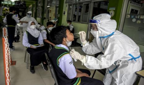 Pelajar menjalani tes usap antigen di SMP Assalaam, Jalan Sasak Gantung, Regol, Kota Bandung, Selasa (25/1/2022). Pemerintah Kota Bandung melalui Dinas Kesehatan Kota Bandung dan Dinas Pendidikan Kota Bandung melakukan tes usap antigen secara acak bagi pelajar dan tenaga pendidik di 60 sekolah berbagai jenjang. Tes usap antigen tersebut dilakukan untuk mengantisipasi penyebaran Covid-19 varian Omicron di sekolah selama pembelajaran tatap muka. Foto: Republika/Abdan Syakura