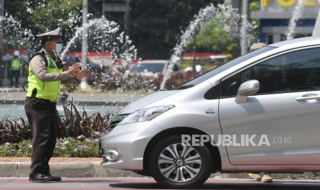 Petugas kepolisian melarang pengendara mobil berplat nomor ganjil memasuki Jalan Sudirman di kawasan Bundaran Senayan, Jakarta, Kamis (12/8/2021). Mulai hari ini, Senin (6/6/2022), Direktorat Lalu Lintas (Ditlantas) Polda Metro Jaya dan Dinas Perhubungan DKI Jakarta menggelar uji coba 13 kawasan ganjil genap baru. 