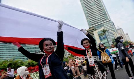 Peserta membentangkan bendera merah putih di kawasan Bundaran HI, Jakarta, Ahad (28/8/2022). Sebanyak 50.000 orang membentangkan bendera merah putih sepanjang 1.700 meter dari kawasan Monas hingga Bundaran HI. Kegiatan tersebut merupakan rangkaian dalam memperingati Hari Kemerdekaan Indonesia dengan tema 