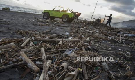 Pelaku wisata membersihkan tumpukan sampah yang berserakan di kawasan Pantai Cemara Sewu, Parangtritis, Kretek, Bantul, DI Yogyakarta, Ahad (16/10/2022). 