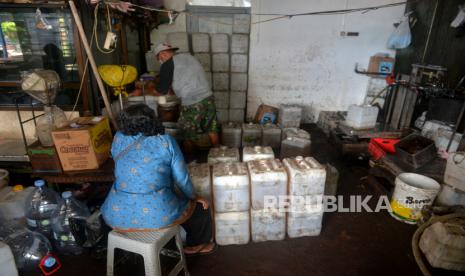 Pekerja melayani pembeli minyak goreng curah di agen minyak goreng, Yogyakarta, Kamis (17/3/2022). Harga minyak goreng curah untuk tingkat agen di Yogyakarta dijual dengan harga Rp 14 ribu per kilogram. Harga ini mengacu dengan aturan Pemerintah terbaru untuk minyak goreng curah. Adanya perubahan peraturan ini pedagang dan UMKM memburu minyak goreng curah karena harganya masih terjangkau.