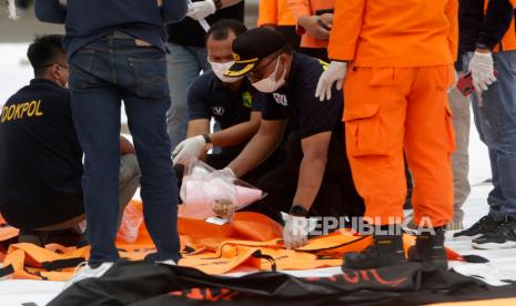 Petugas penyelamat dan Disaster Victim Identification (DVI) Indonesia memeriksa bagian tubuh yang diduga ditemukan selama operasi pencarian puing-puing penerbangan Sriwijaya Air SJ182, di pelabuhan Tanjung Priok di Jakarta, Indonesia, 10 Januari 2021. Kontak dengan penerbangan Sriwijaya Air SJ182 hilang pada 09 Januari 2021 sesaat setelah pesawat lepas landas dari Bandara Internasional Jakarta dalam perjalanan ke Pontianak di provinsi Kalimantan Barat.