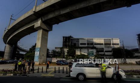 Petugas gabungan memberikan sosialisasi kepada pengendara mobil saat pemberlakuan ganjil genap di kawasan Fatmawati, Jakarta, Senin (25/10). Direktorat Lalu Lintas Polda Metro Jaya hingga saat ini belum ada komunikasi dengan Pemerintah Provinsi DKI Jakarta terkait wacana peniadaan kebijakan ganjil-genap.