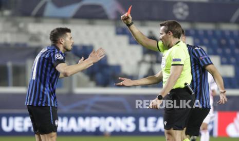 Wasit Tobias Stieler, kanan, menunjukkan kartu merah kepada Remo Freuler dari Atalanta selama Liga Champions, babak 16 besar, pertandingan sepak bola leg pertama antara Atlanta dan Real Madrid, di Stadion Gewiss di Bergamo, Rabu, 24 Februari 2021. 