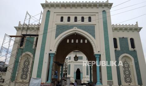 Pekerja mengecat tiang Masjid Raya Al Mashun, di Medan, Sumatra Utara.