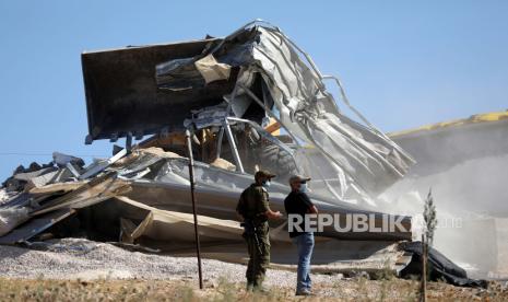  Israel Tolak Bayar Kompensasi Bongkar Empat Rumah Palestina. Polisi perbatasan Israel berjaga-jaga ketika buldoser menghancurkan sebuah rumah di daerah Tepi Barat Masafer, dekat Yatta, 06 Agustus 2020. Masafer Yatta, koleksi 19 dusun Palestina digolongkan sebagai Area C, yang berada di bawah kendali Israel, sejalan dengan Persetujuan Oslo II. Rumah-rumah itu hancur setelah penyewa Palestina mereka tidak memberikan izin yang dibutuhkan Israel untuk membangun infrastruktur di daerah tersebut.