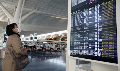 Seorang wanita melihat papan informasi penerbangan di Bandara Internasional Haneda di Tokyo, Jepang, Kamis (14/1). Perdana Menteri Yoshihide Suga mengatakan larangan masuk ke Jepang akan berlaku untuk semua warga negara asing non-residen mulai dari 14 Januari hingga 07 Februari hal itu sebagai tindakan pencegahan dan peningkatan besar kasus Covid-19EPA-EFE / FRANCK ROBICHON