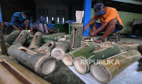 Pekerja membuat kentongan dari bambu. Kentongan dan beduk hingga kini masih menjadi EWS (early warning system). Ilustrasi.