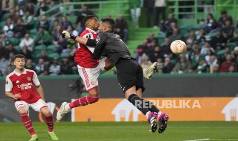  Pemain Arsenal Reiss Nelson (kiri) berebut bola dengan kiper Sporting Antonio Adan pada pertandingan sepak bola babak 16 besar Liga Europa leg pertama antara Sporting CP dan Arsenal di stadion Alvalade di Lisbon,  Jumat (10/3/2023) dini hari WIB.