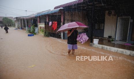 Warga berjalan melintasi banjir di kawasan  permukiman di Batam, Kepulauan Riau, Sabtu (10/8/2024). Sejumlah pemukiman warga di kawasan tersebut terendam banjir akibat hujan lebat sejak pagi dan kurang memadainya sistem drainase di daerah itu. 