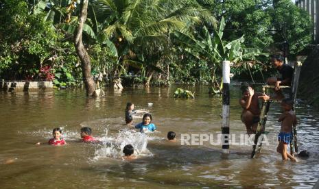 Sejumlah anak berenang di lapangan volley yang terendam banjir di Desa Semuntai, Kabupaten Sanggau, Kalimantan Barat, Senin (15/11/2021). Sebanyak enam kabupaten di Kalimantan Barat yaitu Sanggau, Sekadau, Melawi, Sintang, Kapuas Hulu dan Ketapang terendam banjir akibat tingginya curah hujan selama hampir empat pekan terakhir. 