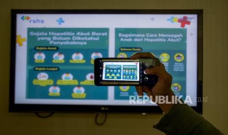 Jurnalis mengambil gambar menggunakan gawai infografis Hepatitis akut di RSUP Dr Hasan Sadikin (RSHS), Pasteur, Kota Bandung, Senin (9/5/2022). Peninjauan tersebut untuk memantau serta memastikan kesiapan RSHS dalam melakukan penyaringan (screening) dan penanganan penyakit Hepatitis akut yang telah dinyatakan Badan Kesehatan Dunia (WHO) sebagai kasus luar biasa (KLB). Hingga saat ini, belum ditemukan kasus Hepatitis akut di Provinsi Jawa Barat. Foto: Republika/Abdan Syakura