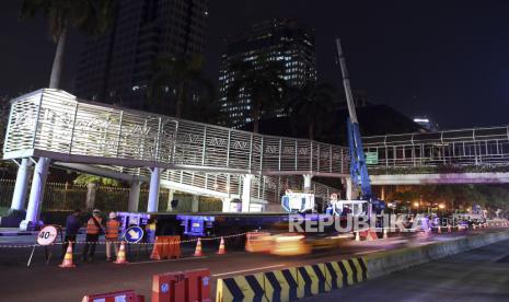 Pekerja mempersiapkan alat berat untuk membongkar Jembatan Penyeberangan Orang (JPO) dan halte TransJakarta Bank Indonesia di Jalan MH Thamrin, Jakarta, Sabtu (5/9/2020) dini hari. JPO dan Halte Bank Indonesia akan dibongkar pada 4-20 September sebagai tahap persiapan konstruksi pembangunan Stasiun Thamrin MRT Jakarta fase II 