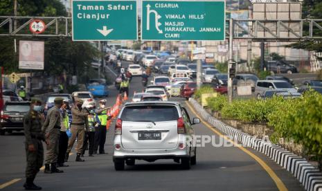 Sejumlah petugas gabungan melakukan penyekatan kendaraan di jalur Puncak saat libur Idul Fitri, Gadog, Bogor, Jawa Barat, Jumat (14/5). Kendaraan yang diperbolehkan melintasi jalur wisata Puncak Bogor hanya kendaraan plat F (Bogor) selain plat tersebut diputar balik petugas sebagai upaya meminimalisir penyebaran COVID-19 di area wisata.Prayogi/Republika.