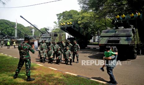 Sejumlah prajurit TNI berfoto di dekat kendaraan alat utama sistem senjata (alutsista) milik TNI yang dipamerkan dalam rangka HUT TNI ke-76 di depan Istana Merdeka, Jakarta, Selasa (5/10). Tema yang diangkat pada peringatan HUT TNI tahun ini adalah Bersatu, Berjuang, Kita Pasti Menang.Prayogi/Republika