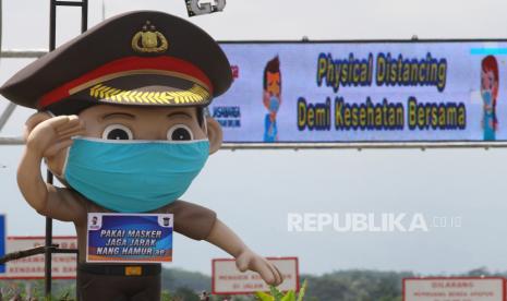 Pengguna jalan melintas di depan patung polisi yang dipasangi masker di pintu keluar tol Malang-Pandaan, Singosari, Malang, Jawa Timur, Sabtu (11/4).(ilustrasi)