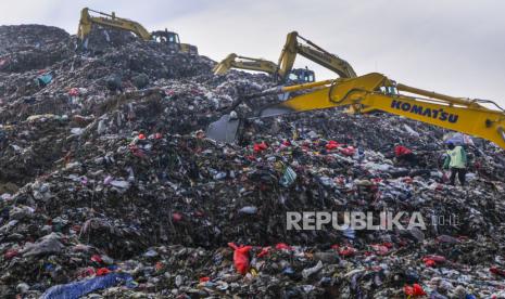 Petugas dengan alat berat mengambil sampah di Tempat Pembuangan Sampah Terpadu (TPST) Bantargebang, Bekasi, Jawa Barat, Senin (1/5/2020). 