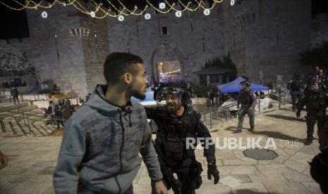 Israel Izinkan Kelompok Sayap Kanan Gelar Pawai Bendera. Seorang polisi Israel berteriak pada seorang pria Palestina untuk meninggalkan Gerbang Damaskus ke Kota Tua Yerusalem setelah bentrokan di kompleks Masjid Al-Aqsa, Jumat, 7 Mei 2021. 