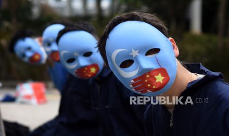 Pengunjuk rasa yang tergabung dalam Koalisi Indonesia Save Uyghur mengenakan topeng saat aksi solidaritas terhadap muslim Uighur di Taman Dukuh Atas, Jakarta, Selasa (4/1/2022). Mereka meminta pemerintah Indonesia untuk berbicara menentang genosida yang terjadi pada muslim Uighur di Xinjiang, memboikot Olimpiade Musim Dingin 2022 di Beijing serta menghentikan deportasi terhadap pencari suaka Uighur kembali ke Tiongkok. 