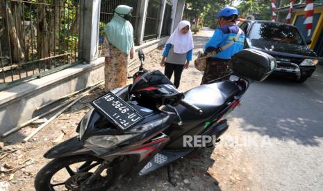 Petugas Muhammadiyah Covid-19 Command Center (MCCC) memberi dan memasangkan masker kepada warga yang tidak menggunakan di Sanden, Bantul, Yogyakarta, Ahad (9/8). Pemberian masker secara gratis kepada warga oleh MCCC ini dalam rangka penerapan kebiasaan baru protokol kesehatan Covid-19. Dalam adaptasi kebiasaan baru ini lonjakan kasus Covid-19 cukup tinggi.