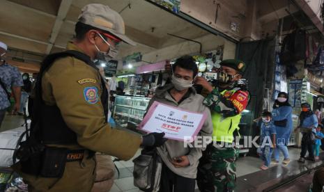 Anggota Satuan Polisi Pamong Praja Kota Salatiga dan prajurit TNI memberikan masker kepada warga yang tidak menggunakan masker saat patroli edukasi protokol kesehatan di Pasar Raya II, Salatiga, Jawa Tengah, Rabu (20/5/2020). Patroli gabungan tersebut guna mengedukasi tentang protokol kesehatan kepada masyarakat seperti penggunaan masker saat di tempat umum sebagai antisipasi penularan COVID-19