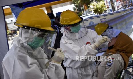 Petugas medis dari Dinas Kesehatan Kota Bandung mengambil sampel lendir dari seorang anggota Satpol PP saat test swab Covid-19 di Pos Pemeriksaan Pembatasan Sosial Berskala Besar (PSBB), Gerbang Tol Pasteur, Kota Bandung, Kamis (14/5). Tren penyebaran Covid-19 saat ini terus mengalami peningkatan di Bandung.