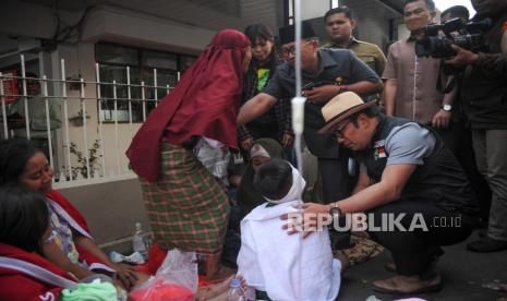 Gubernur Jawa Barat Ridwan Kamil (kanan) berbincang dengan seorang warga korban gempa yang mendapat perawatan di RSUD Sayang, Kabupaten Cianjur, Jawa Barat, Senin (21/11/2022). Ridwan Kamil juga meninjau kondisi RSUD dan lokasi gempa lainnya. 