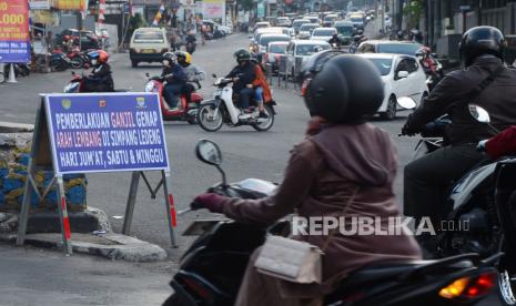 Plang pemberitahuan pemberlakukan ganjil genap arah Lembang dipasang di pertigaan Gegerkalong, Jalan Stiabudi, Kota Bandung, Ahad (19/9). Aturan tersebut diterapkan untuk kendaraan roda empat di saat akhir pekan untuk mengendalikan volume kendaraan yang menuju kawasan wisata Lembang, Kabupaten Bandung Barat.