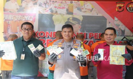 Kapolres Sukabumi AKBP Maruly Pardede memperlihatkan barang bukti kasus peredaran uang palsu dolar Amerika di Mapolres Sukabumi, Ahad (9/7/2023).