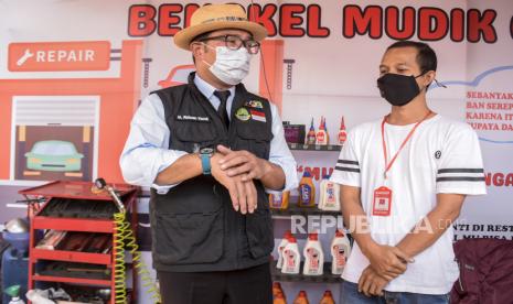 Gubernur Jawa Barat Ridwan Kamil (kiri) berbincang dengan mekanik di area Bengkel Mudik Gratis di Pos Terpadu Limbangan, Limbangan, Garut.   Gubernur Jawa Barat Ridwan Kamil menilai keputusan menunda jadwal masuk sekolah merupakan langkah solutif untuk mengantisipasi kemacetan yang diprediksi terjadi saat arus balik Lebaran tahun ini.