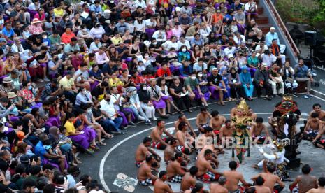 Wisatawan menyaksikan penampilan penari yang menampilkan atraksi wisata Tari Kecak Uluwatu di kawasan Uluwatu, Badung, Bali, Rabu (28/12/2022). 