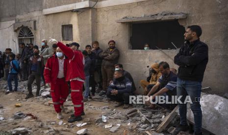 Warga Palestina mencari jenazah di sebuah rumah yang terkena serangan Israel di Rafah, Jalur Gaza pada Rabu, (27/3/2024).