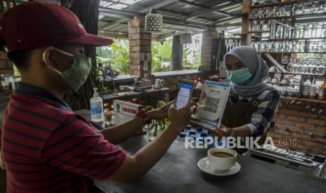 Konsumen melakukan transaksi pembayaran menggunakan aplikasi uang elektronik BJB DigiCash di usaha kuliner dan kopi Warung Pinus, Sagalaherang, Kabupaten Subang, Jawa Barat, Jumat (4/12/2020).  PT Bank Pembangunan Daerah Jawa Barat dan Banten, Tbk. (Bank BJB) hadir mendukung program Pemerintah Jawa Barat untuk membangun Kawasan Rebana Metropolitan yakni salah satunya dengan transformasi transaksi dan kredit perbankan secara digital bagi masyarakat dan pelaku UMKM melalui aplikasi BJB Digi dan BJB DigiCash. 