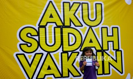 Anak-anak menunjukkan kartu vaksin usai vaksinasi 