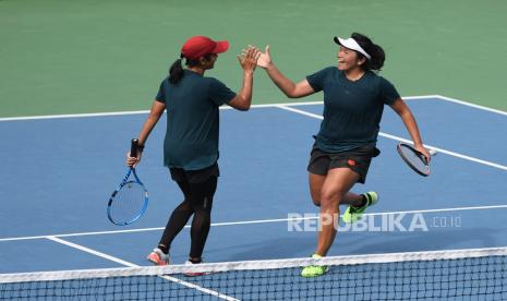 Ganda putri Jawa Timur Jessy Rompies (kanan) dan Nadia Ravita (kiri) meluapkan kegembiraannya usai mengalahkan pasangan asal Papua Barat Nadya Syarifah/Kadek Gita Purnami dalam pertandingan penyisihan grup tenis beregu putri PON Papua di Jayapura, Papua, Selasa (28/9/2021). 