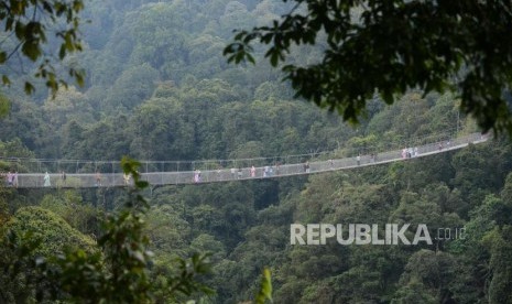 Wisatawan  melintasi Situ Gunung Suspension Bridge di Taman Nasional Gunung Gede Pangrango, Kadudampit, Sukabumi, Selasa (19/6).