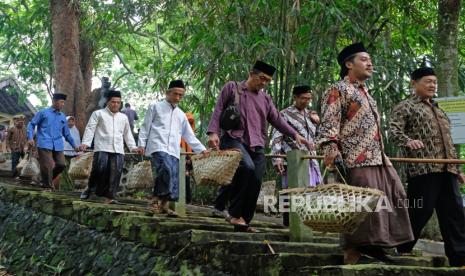 Sejumlah warga membawa keranjang anyaman bambu berisi bermacam makanan saat tradisi Nyadran Suroloyo Sepujud di Soropadan, Pringsurat, Temanggung, Jawa Tengah, Jumat (1/3/2024).  Tradisi Nyadran rutin dilaksanakan masyarakat setempat setiap Jumat Pahing bulan Sya