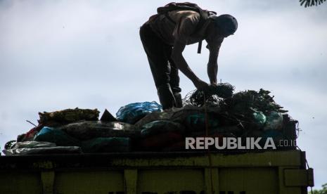 Pekerja berada di atas truk sampah yang antre masuk ke Tempat Pembuangan Akhir (TPA).