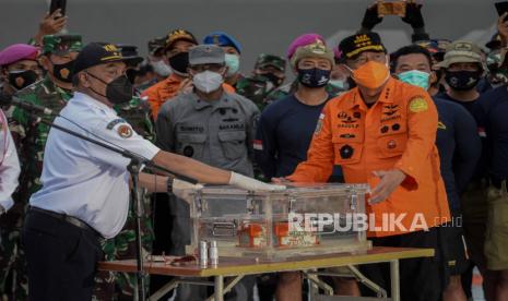 Kepala BASARNAS Marsekal Madya TNI Bagus Puruhito (kanan) menyerahkan Flight Data Recorder (FDR) pesawat Sriwijaya Air PK-CLC dengan nomor penerbangan SJ-18 yang jatuh di perairan Pulau Seribu kepada Ketua Komisi Nasional Keselamatan Transportasi (KNKT) Soerjanto Tjahjono (kiri), di Dermaga JICT, Jakarta, Selasa (12/1).