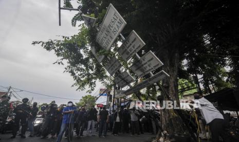 Sejumlah warga merobohkan plang Sekretariat FPI di kawasan Petamburan, Jakarta, Rabu (30/12). Aparat gabungan dari TNI dan Polri mendatangi kawasan Petamburan III untuk mencabut sejumlah atribut FPI pasca pembubaran organisasi tersebut oleh pemerintah. Republika/Putra M. Akbar