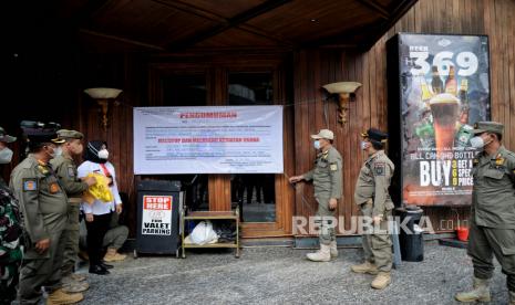 Petugas Satpol PP bersama Dinas Pariwisata dan Ekonomi Kreatif, serta TNI  melakukan penyegelan di salah satu bar-resto Holywings di Jakarta, Selasa (28/6/2022). Ketua Fraksi PSI sebut harusnya Pemprov DKI malu karena kecolongan izin Holywings.