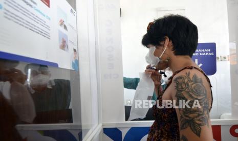 Calon penumpang meniupkan nafas ke dalam kantong untuk di tes menggunakan alat GeNose C19 di Bandara Radin Inten II Lampung Selatan, Lampung, Senin (19/4/2021). Pembukaan layanan Posko GeNose C19 bagi calon penumpang di Bandara tersebut sebagai upaya pencegahan penyebaran COVID-19 serta memudahkan calon penumpang dalam melengkapi persyaratan penerbangan dengan tarif Rp40 ribu. 