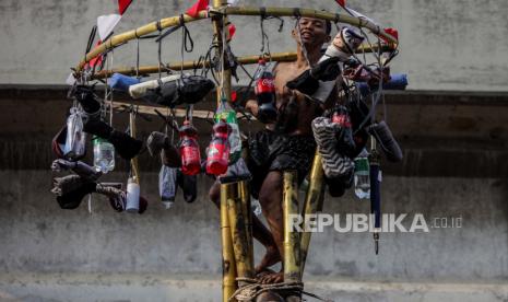 Warga mengambil hadiah saat mengikuti lomba panjat pinang di atas Kalimalang, Cipinang Melayu, Makasar, Jakarta Timur, Sabtu (19/8/2023). Warga RW 04 Cipinang Melayu mengadakan berbagai perlombaan panjat pinang dan gebuk bantal untuk memeriahkan Kemerdekaan Indonesia ke-78. Perlombaan yang sudah menjadi tradisi setiap Kemerdekaan Indonesia dengan tujuan untuk menghibur warga tersebut diikuti oleh sembilan RT. 