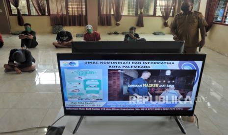 Sumsel Siapkan Pergub Atur Sanksi tidak Pakai Masker. Foto: Sejumlah warga yang terjaring razia masker diberikan edukasi melalui tayangan informasi terkait COVID-19,  di Asrama PGRI Plaju Palembang, Sumsel, Selasa (19/5/2020). Para warga yang melanggar aturan masker selain harus menjalani karantina semalam juga harus menyimak tayangan edukasi COVID-19 sebagai bentuk sanksi sekaligus edukasi