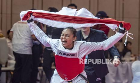 Atlet Taekwondo Indonesia Megawati Tamesti Maheswari melakukan selebrasi sambil membawa bendera merah putih usai menang melawan atlet Taekwondo Thailand Chutikan Jongkolrattanawattana pada pertandingan taekwondo ‘under’ 53 kilogram putri SEA Games 2023, di Chory Changvar International Convention and Exibhition Center, Phnom Penh, Kamboja, Senin (15/5/2023). Megawati Tamesti Maheswari berhasil meraih medali emas usai mengalahkan atlet taekwondo Thailand dengan skor 2-1, sementara medali perak diraih atlet taekwondo Thailand Chutikan Jongkolrattanawattana serta medali perunggu diraih atlet taekwondo Filipina Baby Jessica Canabal dan atlet taekwondo Kamboja Mam Julie. ANTARA FOTO/Muhammad Adimaja/hp.