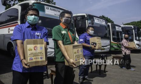 Sopir bus membawa paket sembako yang diterimanya dalam kegiatan Bakti Kesehatan dan Bakti Sosial Korlantas Polri di PO Doa Ibu Pool, Ciracas, Jakarta, Jumat (25/9/2020). Kegiatan tersebut dalam rangka Hari Lalu Lintas Bhayangkara ke-65. 