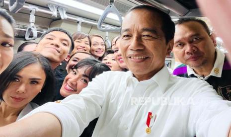 Presiden Joko Widodo dengan penggiat seni menggunakan LRT.