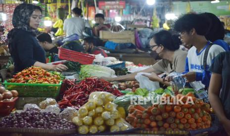 Masyarakat berbelanja komoditas bahan pokok di pasar.